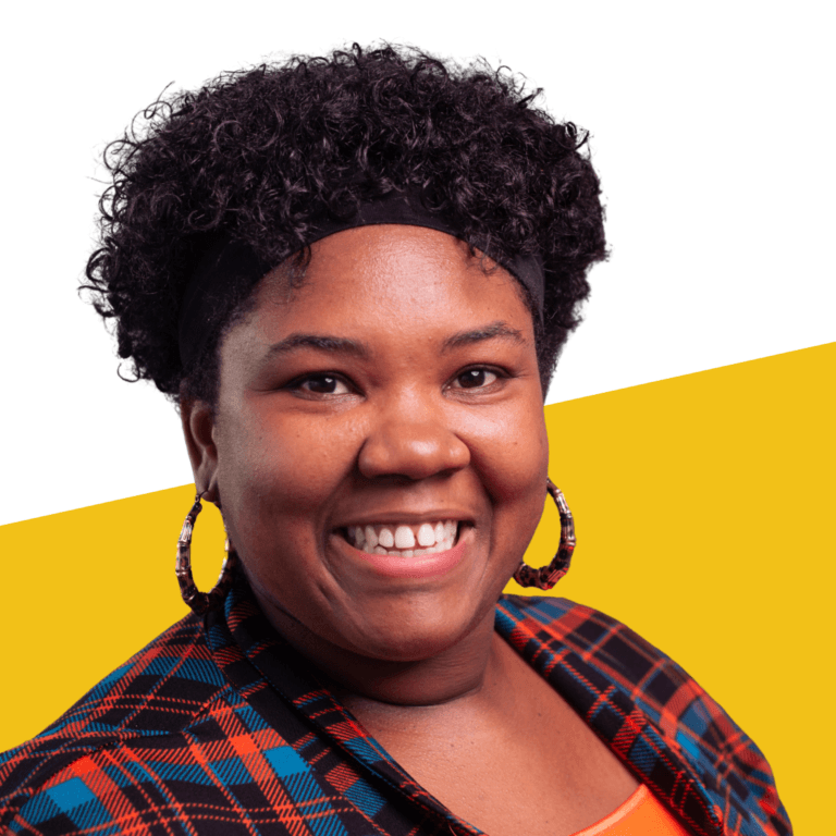 Smiling woman with curly hair, hoop earrings, and a plaid jacket, standing in front of a white and yellow background, representing student leadership network staff.