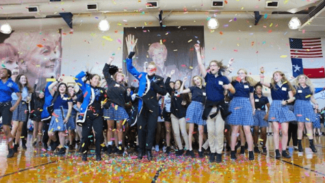Students throw confetti in the air and some are jumping. There is a large banner of the school's namesake, Ann Richards, in the background.