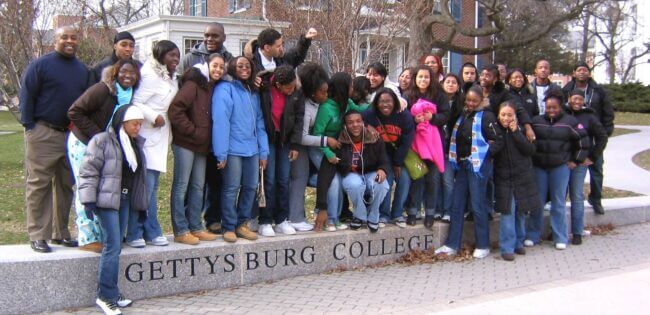 A group of students stand at the entrance to Gettysburg College during a campus visit.