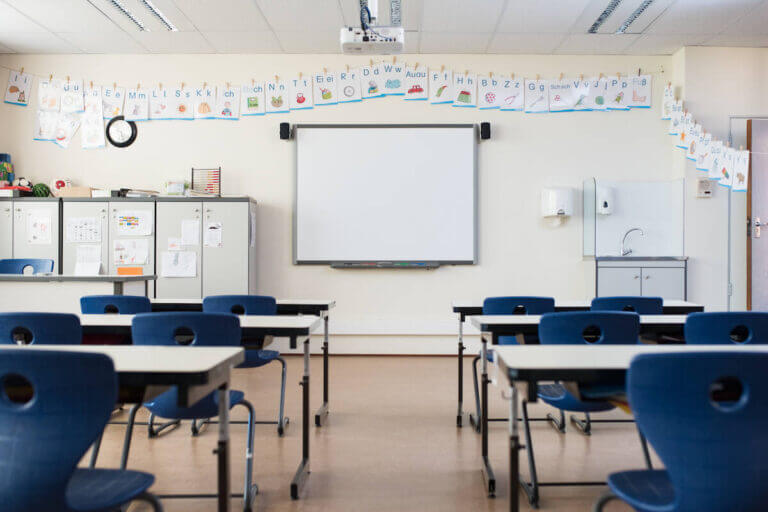 An empty classroom with desks and seats ready to be filled with eager students.