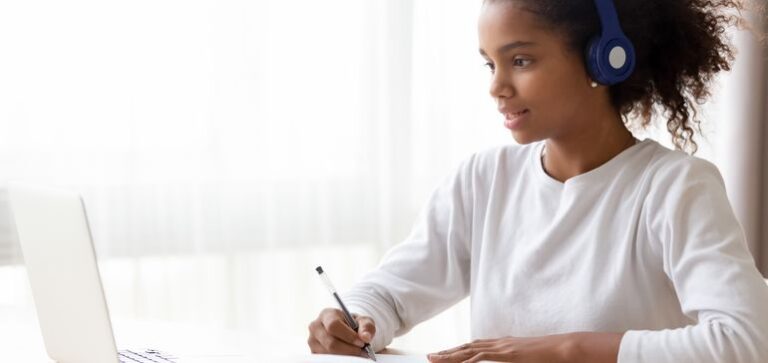 A student wearing headphones and studying.