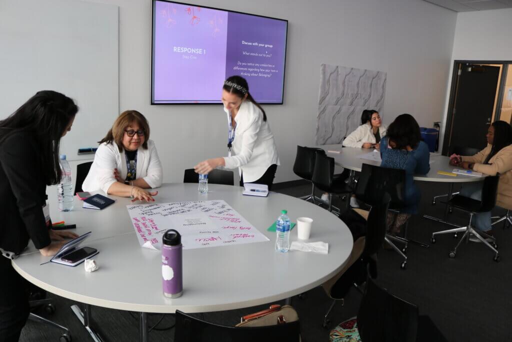 Educators work together around tables in interactive workshop