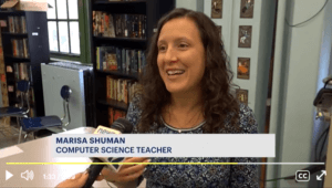 Computer science teacher Marisa Shuman talks into microphone.