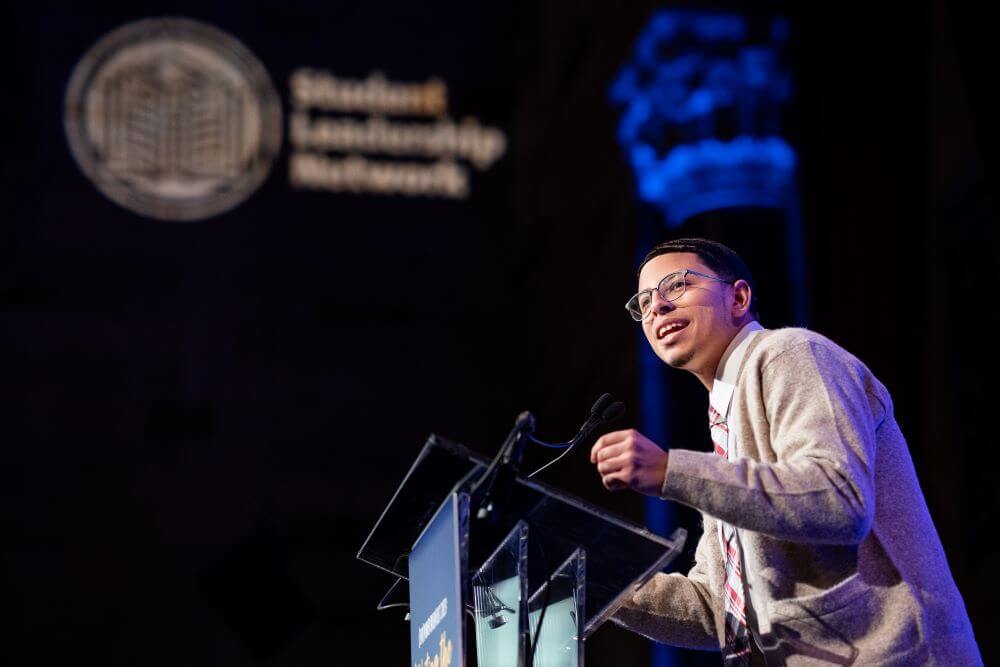 Alumnus Manny Salazar speaks at podium