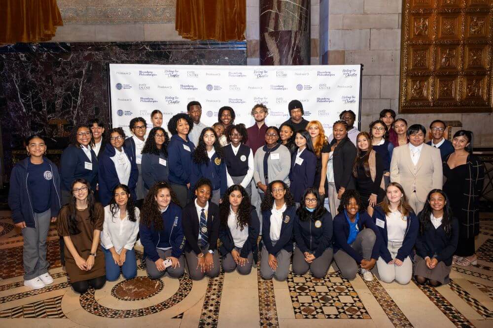 Group of students pose for photo in front of Student Leadership Network backdrop