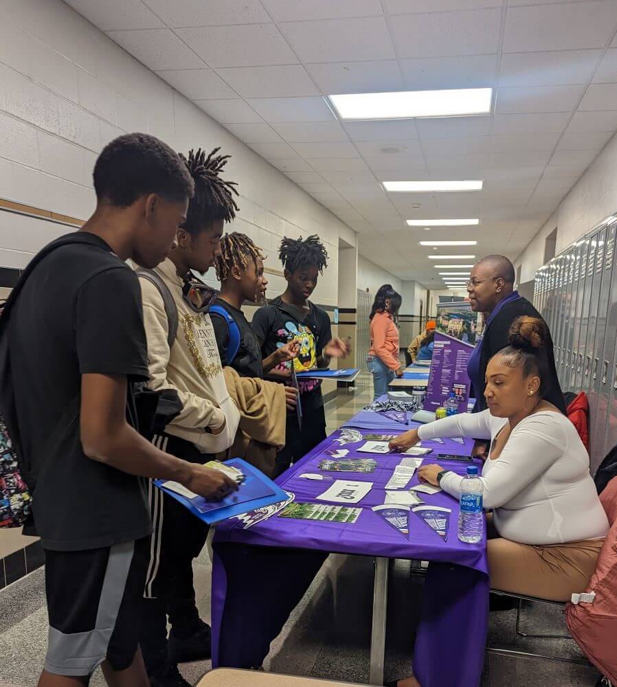 Students talk to college admissions representatives at a college fair
