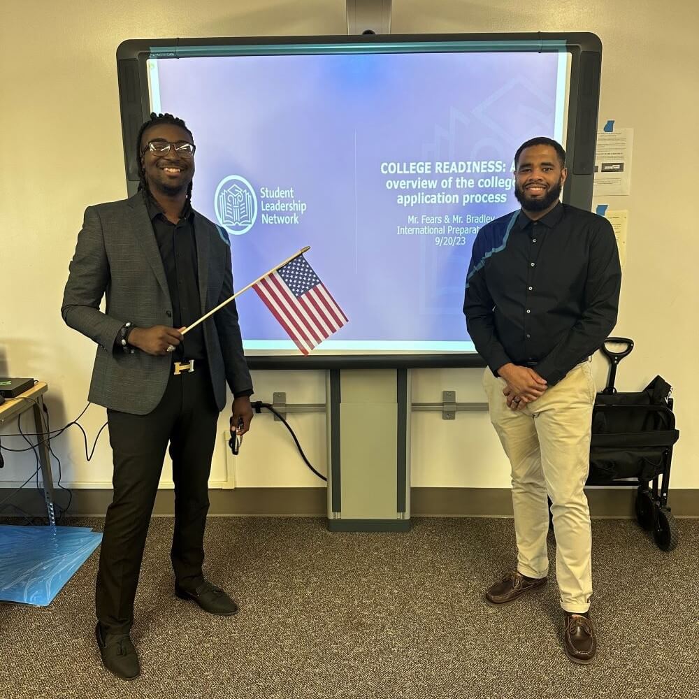 Two men stand in front of presentation screen with title "College Readiness" in background