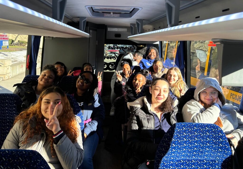 Students aboard a bus get ready to visit colleges.