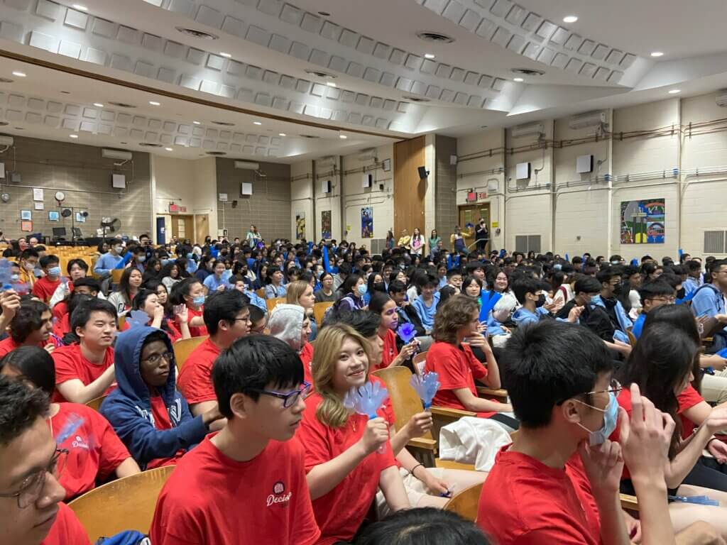 Students hold up clappers and noisemakers in schoolwide assembly