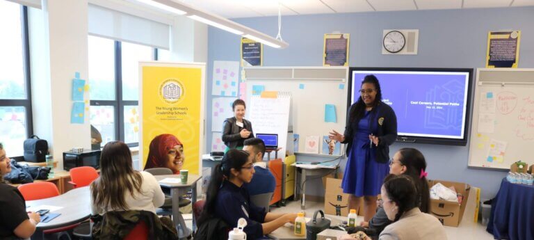 Principal welcomes volunteers at front of classroom