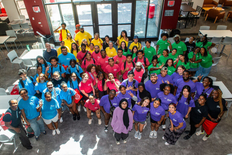 Students and staff in colorful shirts post for group photo
