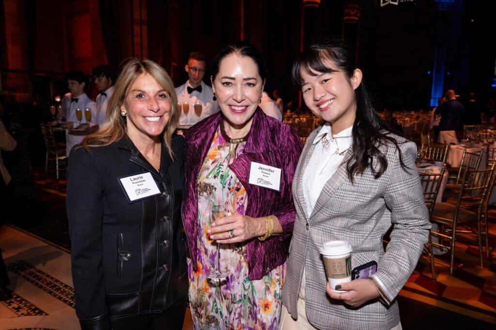 Guests in professional and festive attire pose for photo