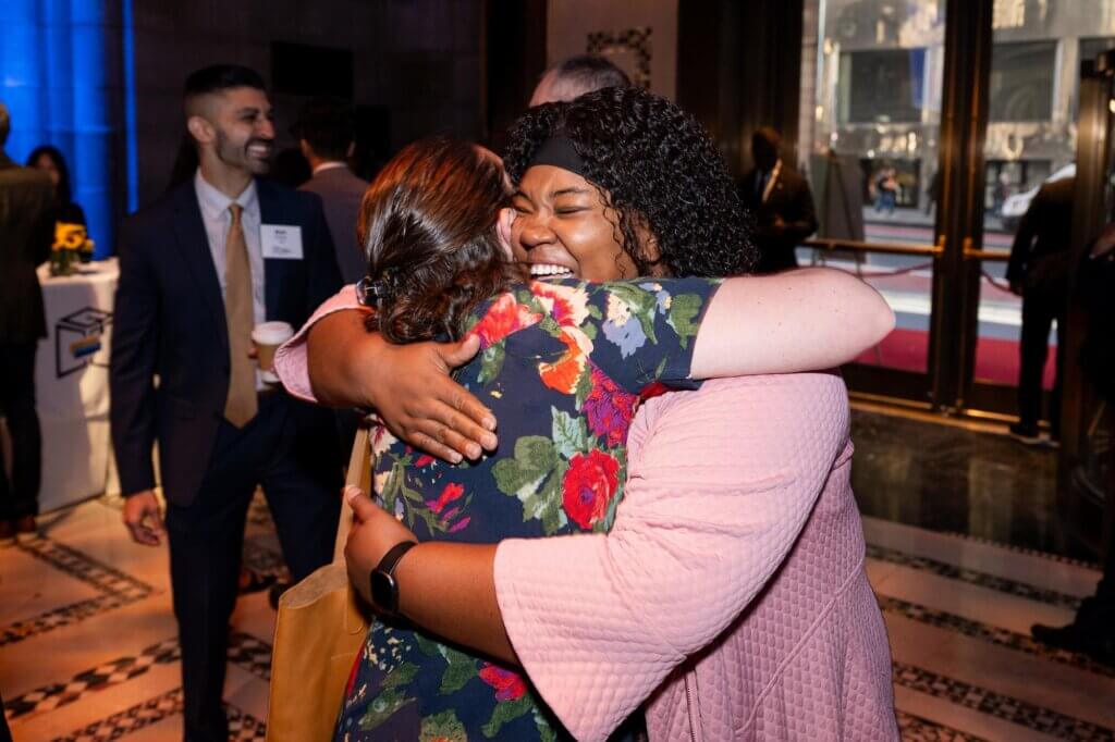 Two guests hugging with joyful expressions