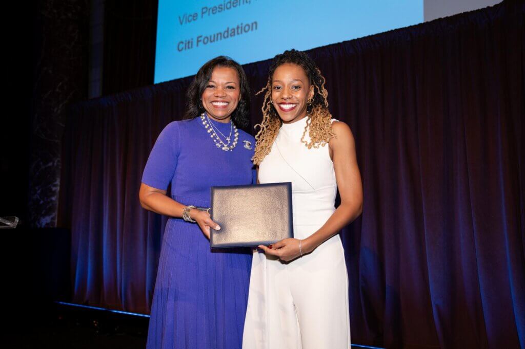 Erika Irish Brown and Kenya Bryant hold certificate on stage