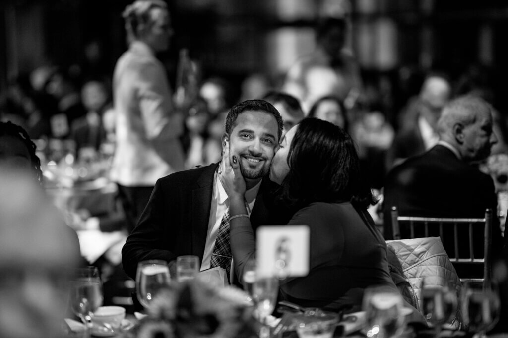 Event honoree Angel Santana receives a congratulatory kiss from his wife