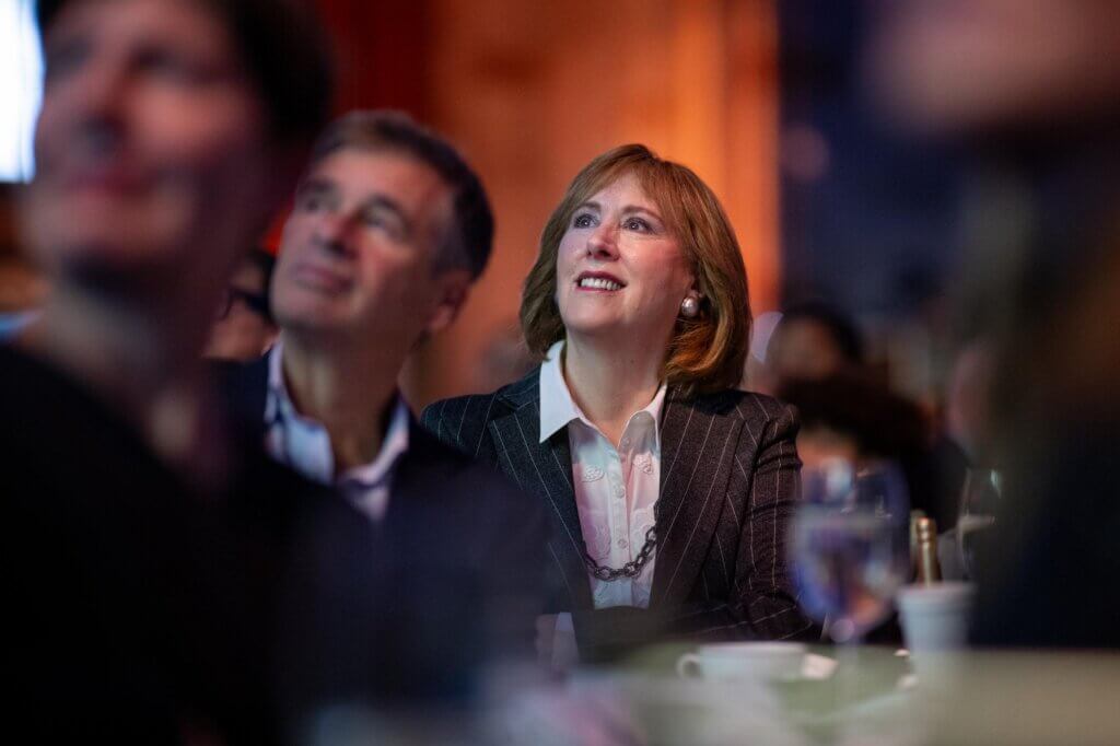 Ann Tisch looks up to the stage with excitement