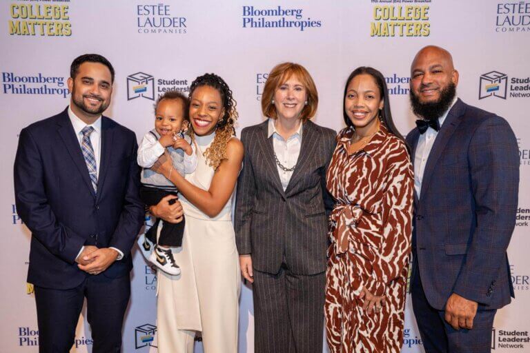 Event honorees and speakers pose for photo in front of event backdrop