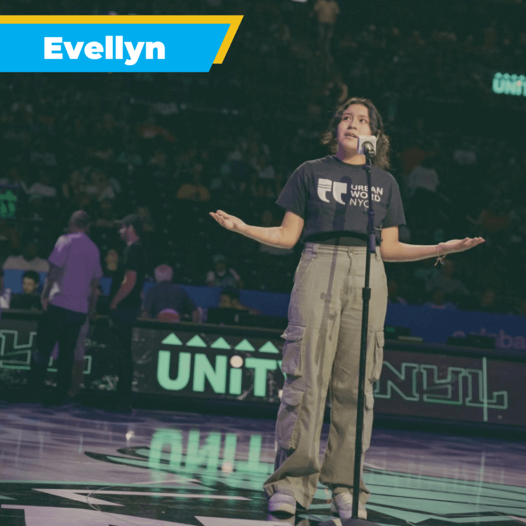 Student holds arms up while she performs spoken word poetry into a microphone stand