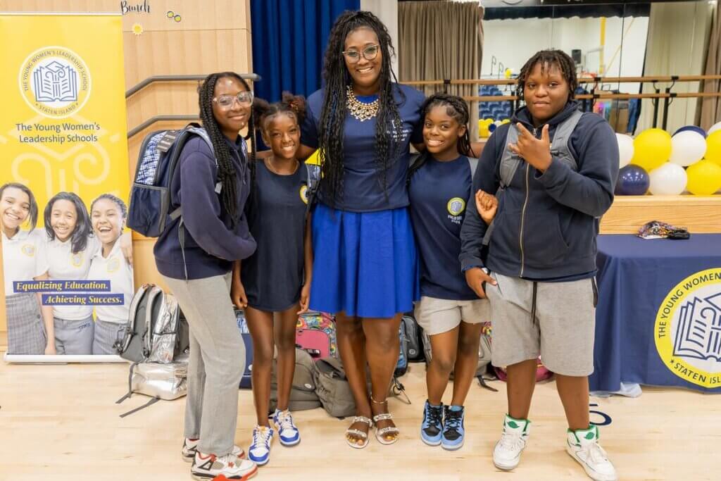 Principal Aisha Shepard and students pose for a photo in the school auditorium