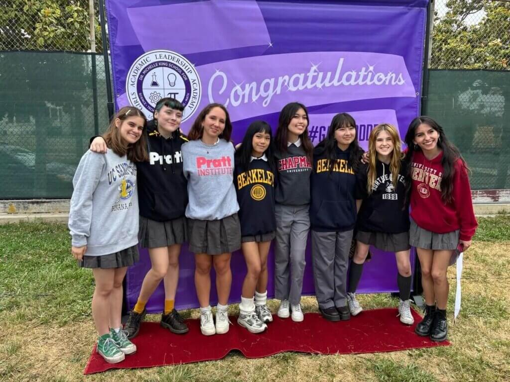 GALA students pose wearing their college gear at the College Signing Day celebration.