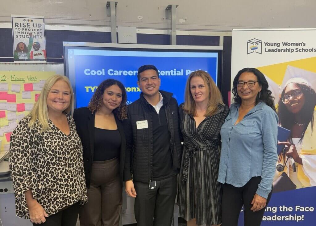 Principal with four of her former students in a classroom