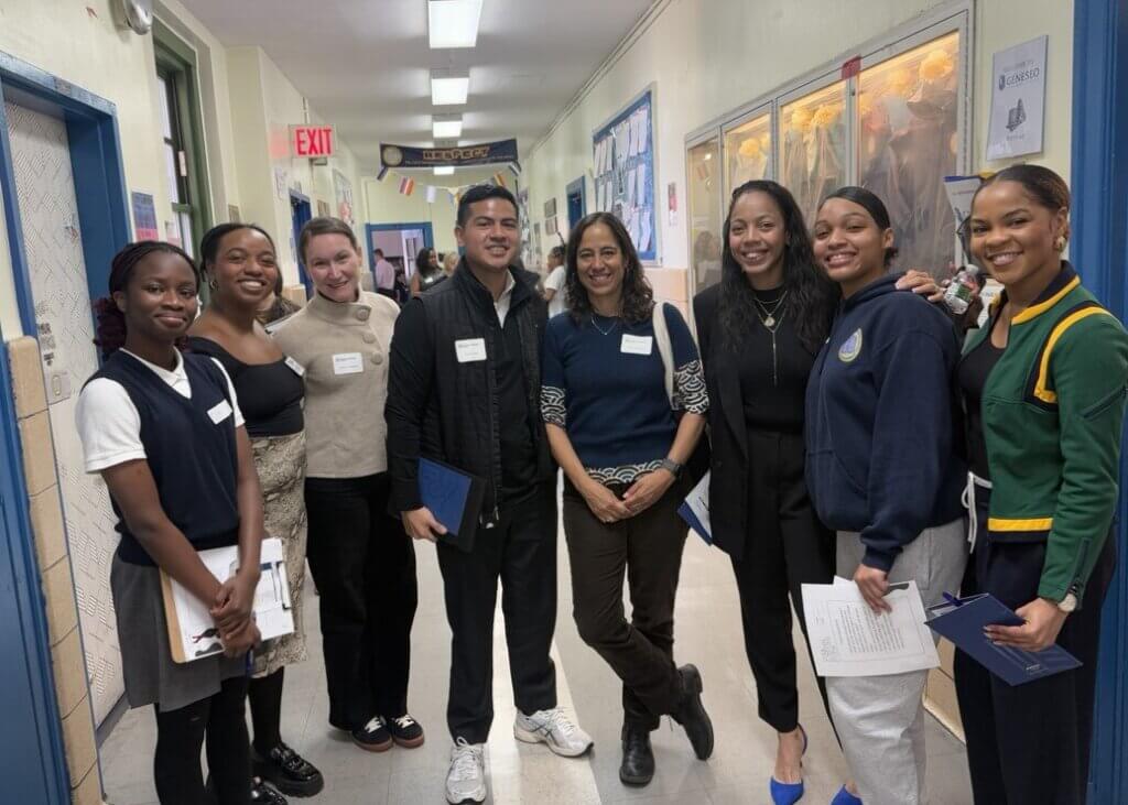 Group of students and volunteers walk along school hallway