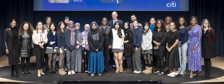 Students on stage with Ursula Burns pose for group photo