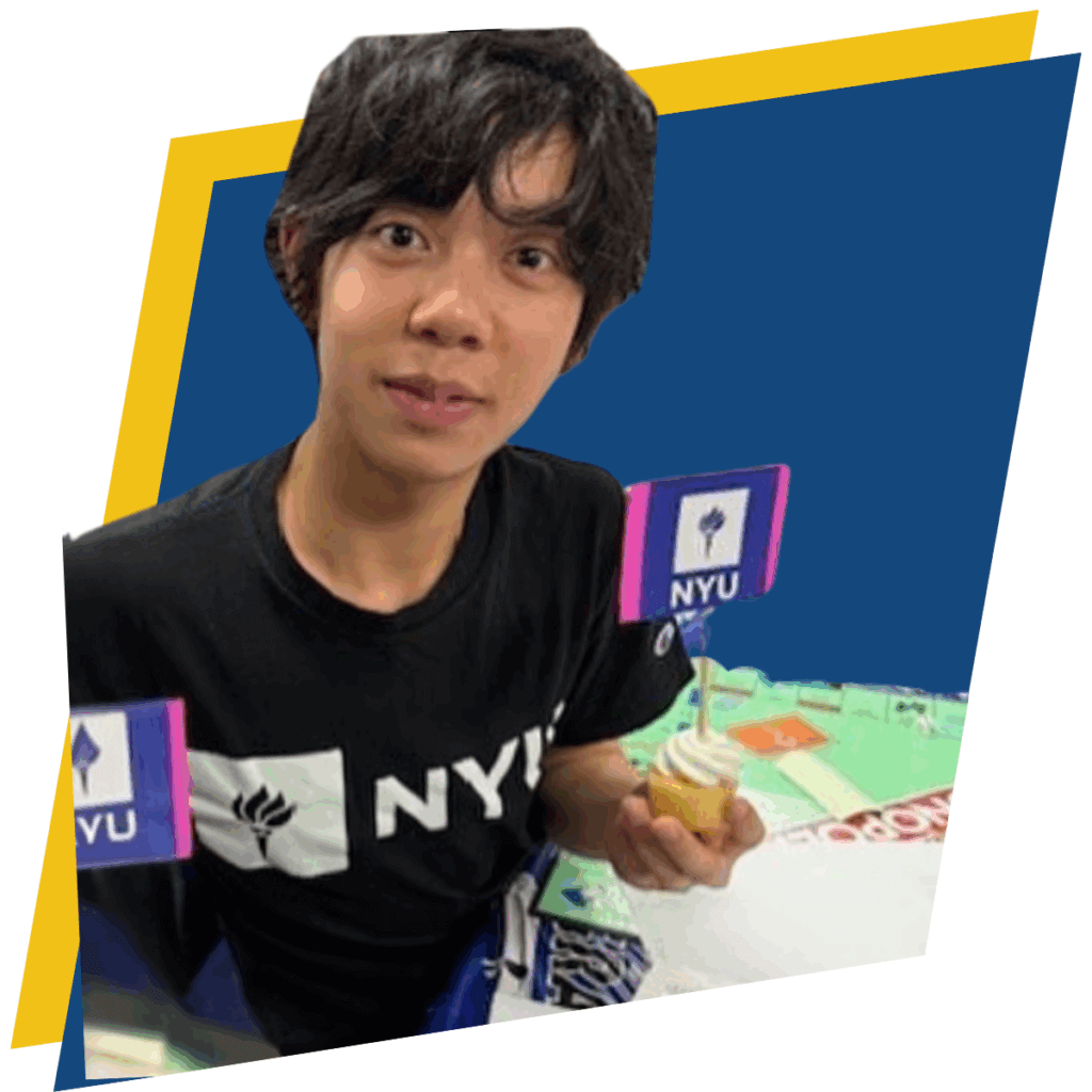 Young person wearing an NYU shirt, holds a cupcake with an NYU flag on it, celebrating his journey to college at NYU