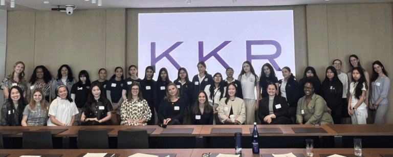 A group of women pose for a photo in a conference room at KKR