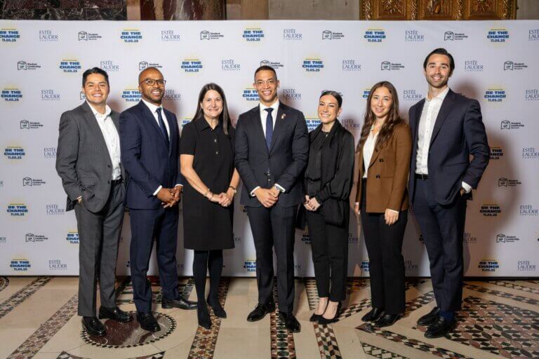 Bloomberg team stands, smiling, in front of a step-and-repeat banner at the (Em)Power Breakfast