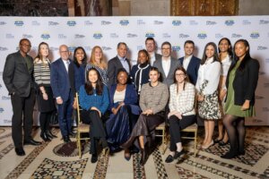 A group RBC team members pose together in front of a step-and-repeat banner at the (Em)Power Breakfast