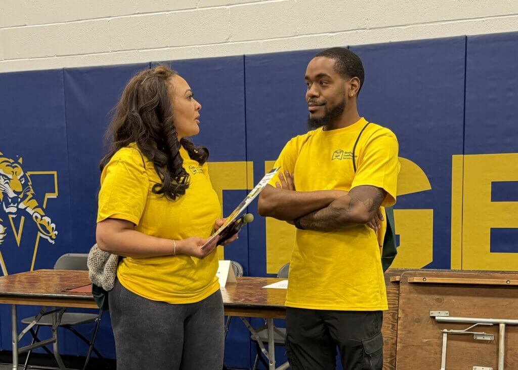 Two college counseling chaperones talk inside an HBCU fair