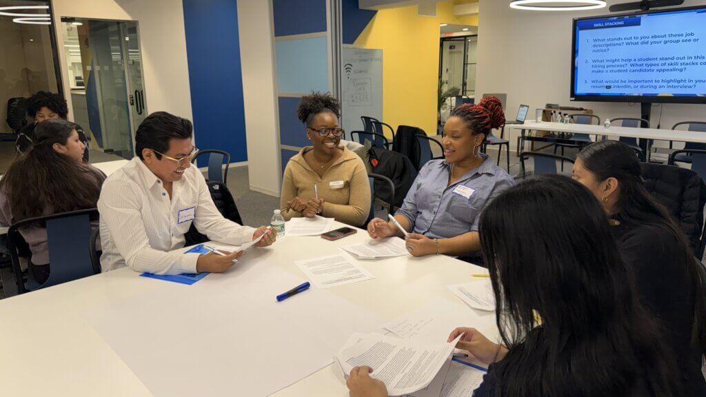 Five people sit at a table, discussing skills they have and skills they can develop if taking gap time from school