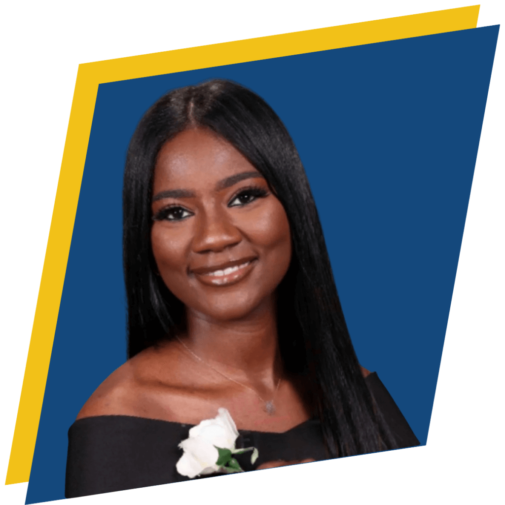 A woman with straight black hair wearing an off-the-shoulder black top holds a white rose, smiling at the camera for her graduation photo.