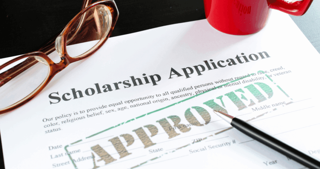 A paper application form for a scholarship for college is stamped APPROVED