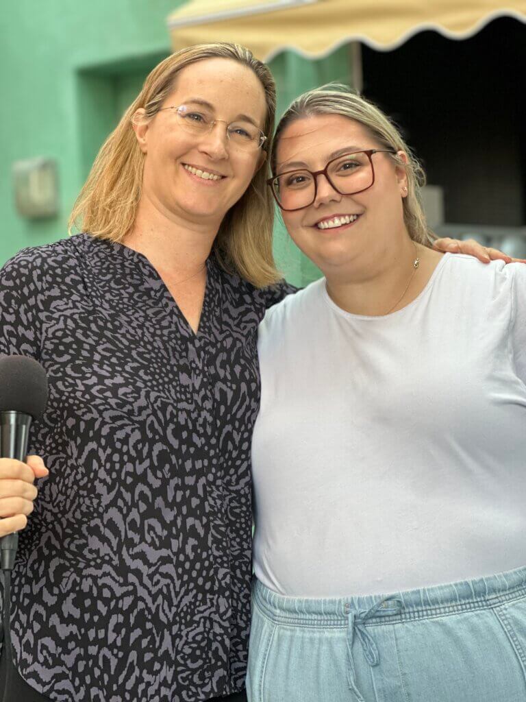 Two women standing close together and smiling at the camera for the network's April Blount Awards