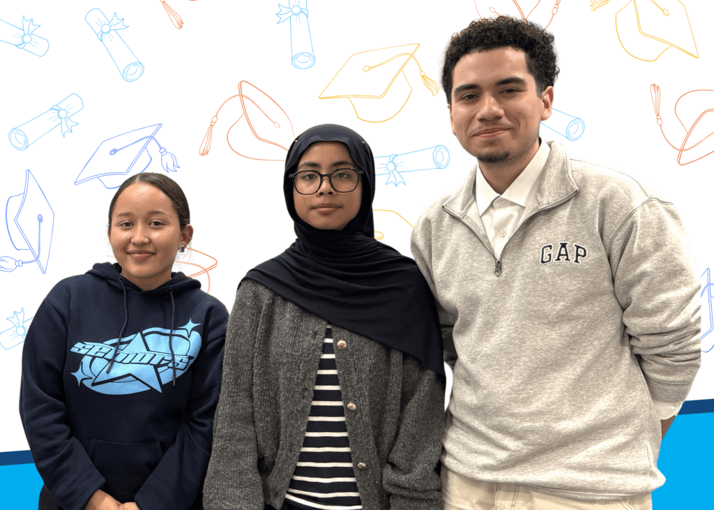 Three students stand side by side, posing for a photo in front of a backdrop with graduation caps and diplomas.