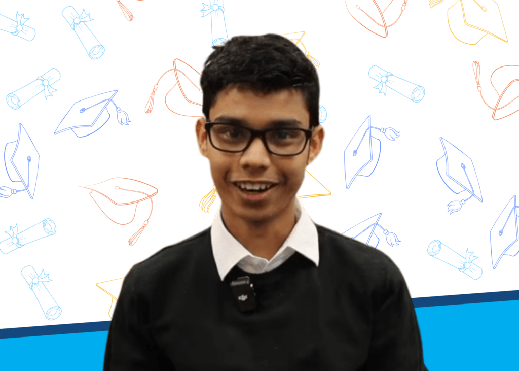 A young person wearing glasses and a black sweater over a white shirt smiles at the camera, with a background featuring graduation caps and diplomas in blue and orange outlines.