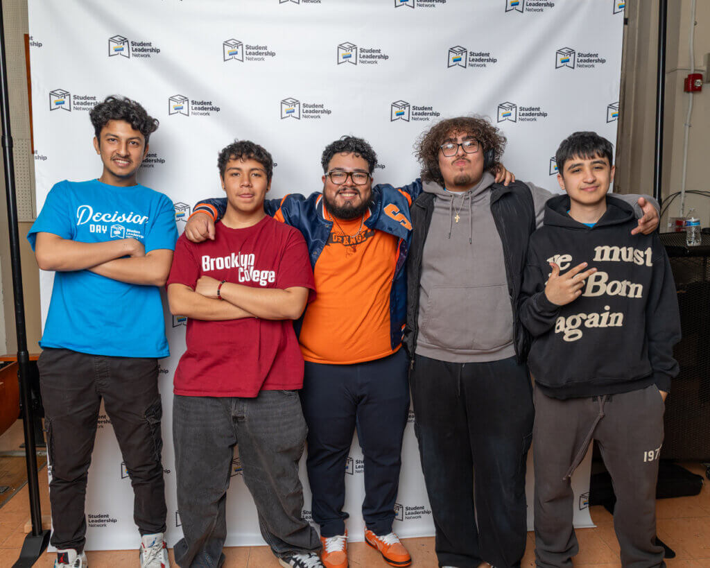 Five young men stand together in front of a Student Leadership backdrop, posing for a group photo with arms around each other for the 2025 Annual Report.